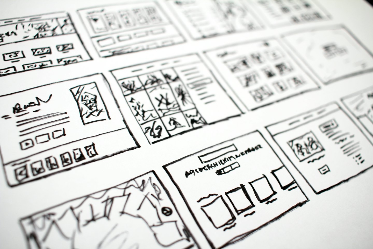 Hand-drawn wireframes for website layouts on white paper.
